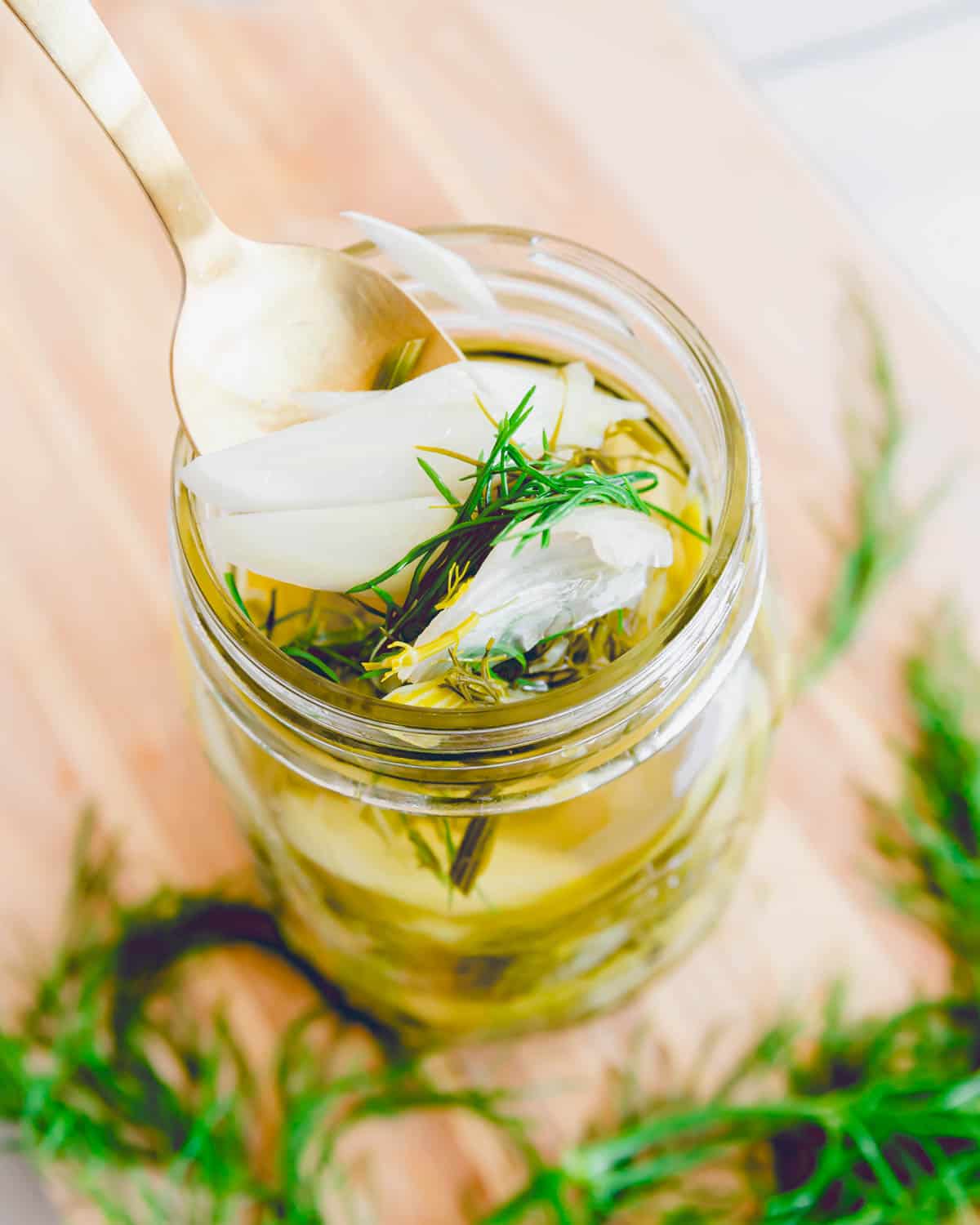 Quick pickled fennel in a jar with a spoon.
