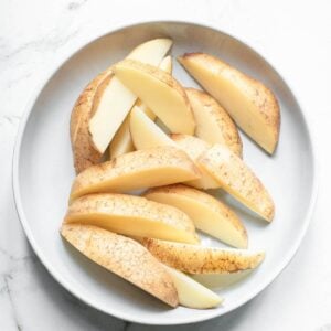 Potato wedges on a white plate.