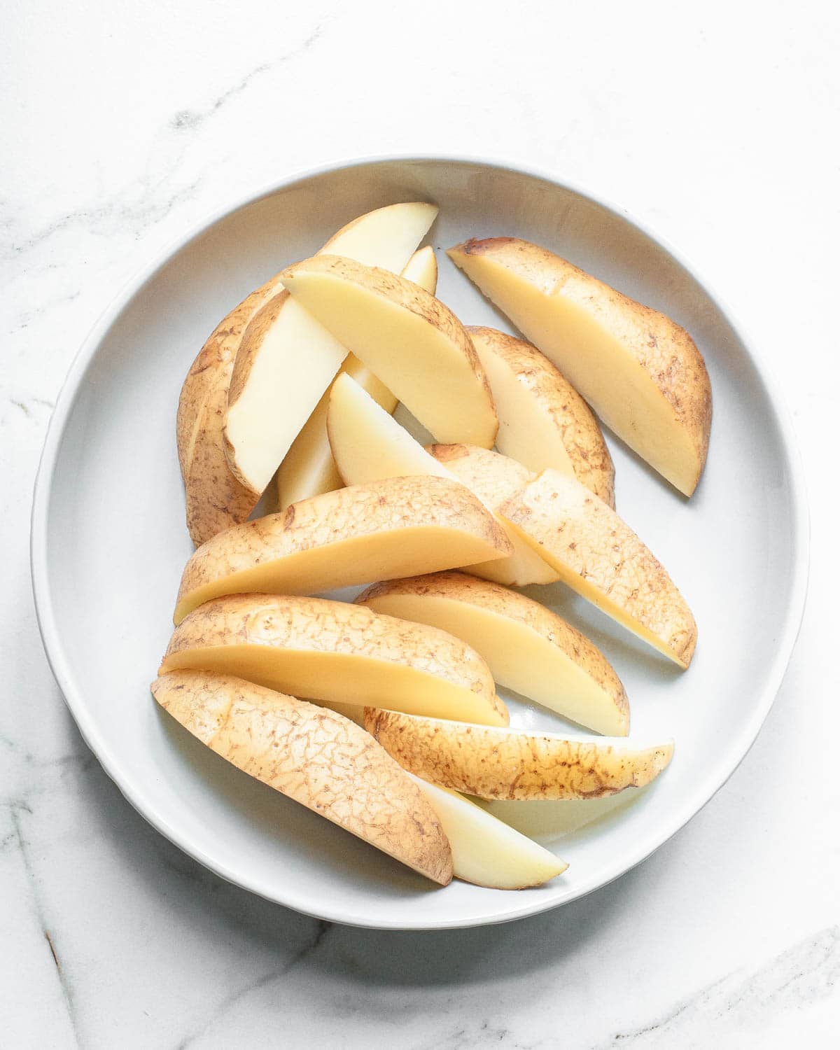 Potato wedges on a white plate.