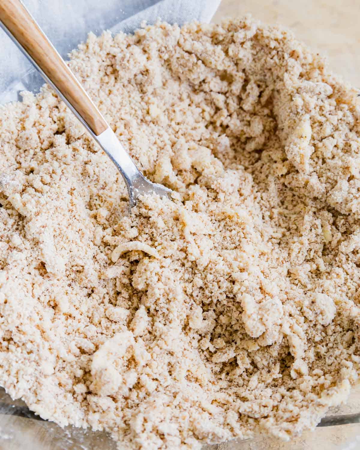 Butter cut into cobbler flour mixture in a glass bowl.