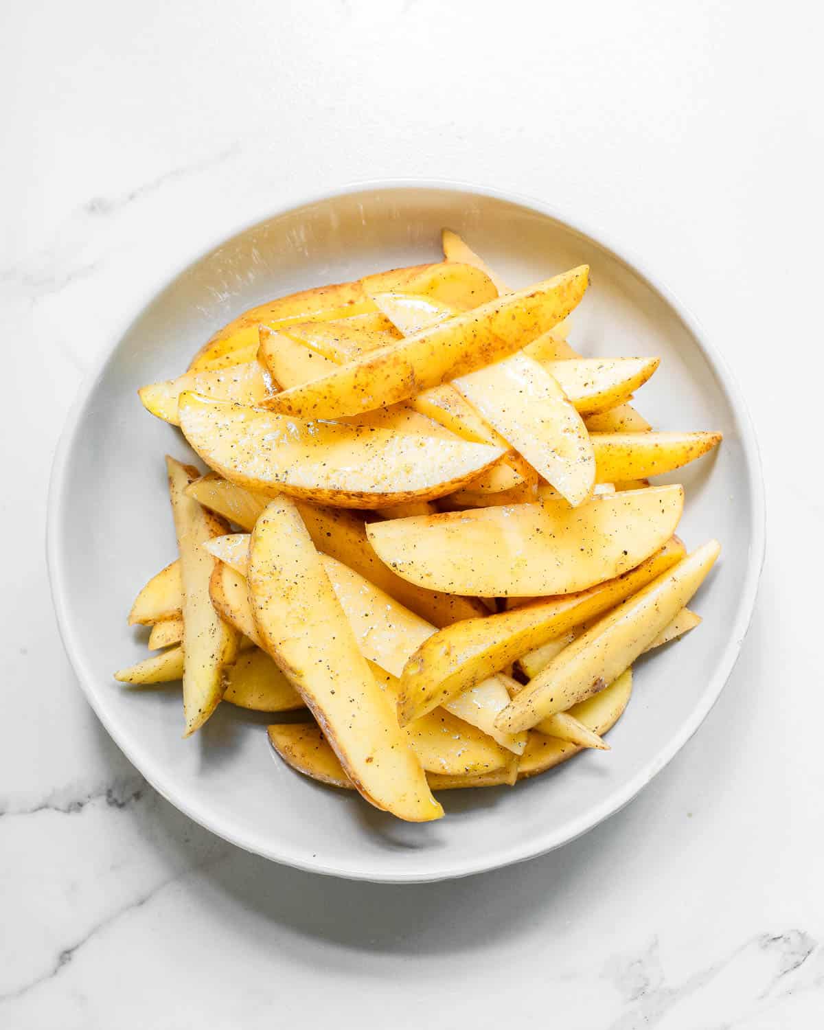 Seasoned potato wedges on a plate.