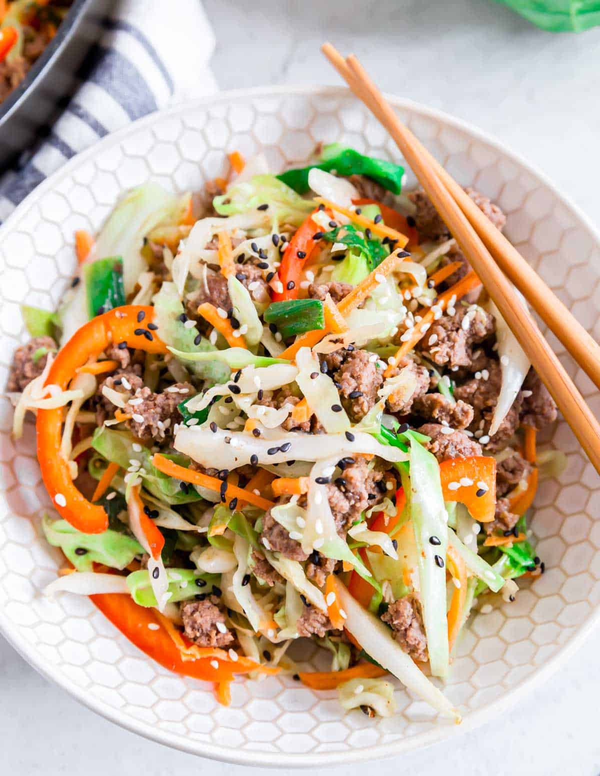 Ground beef and cabbage skillet dinner in a bowl with chopstick on the side.