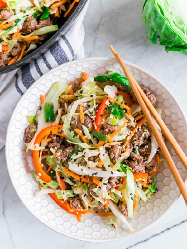 Ground beef cabbage stir fry in a bowl with chopsticks resting on the side.