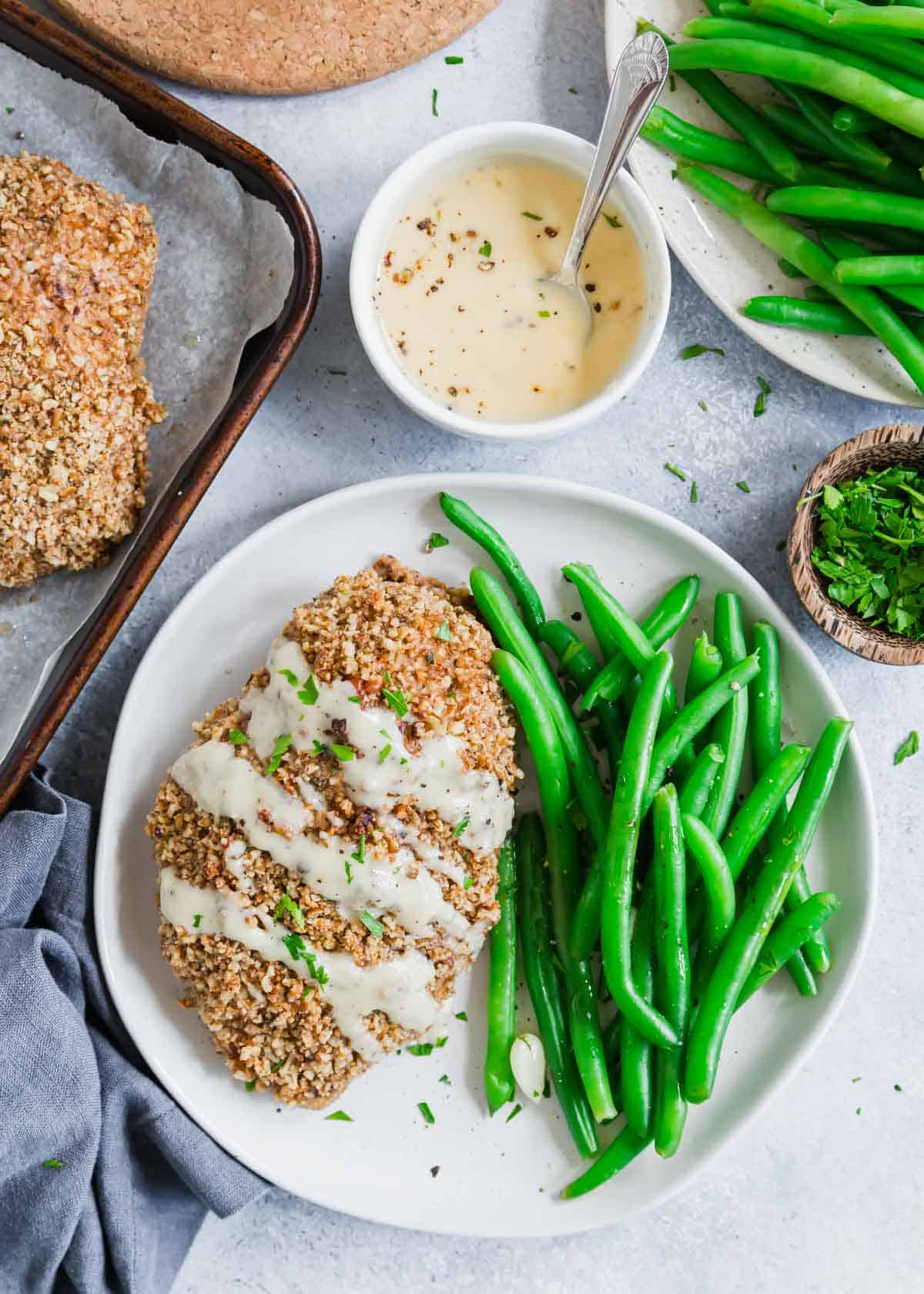 Overhead shot of pecan chicken with honey dijon sauce and green beans.