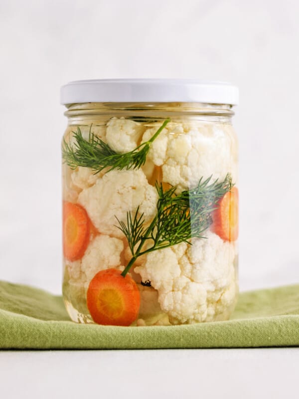 A jar with fermented cauliflower and carrots in it.