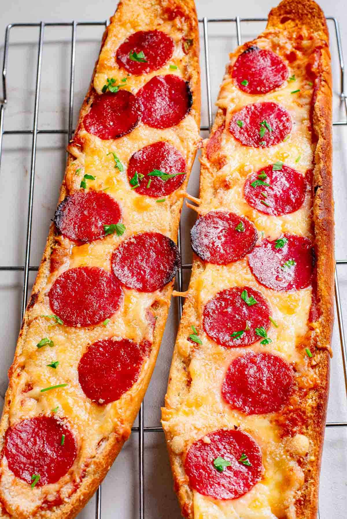 Two slices of pepperoni pizza bread on a cooling rack.