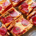 Pepperoni garlic pizza bread on a cooling rack.