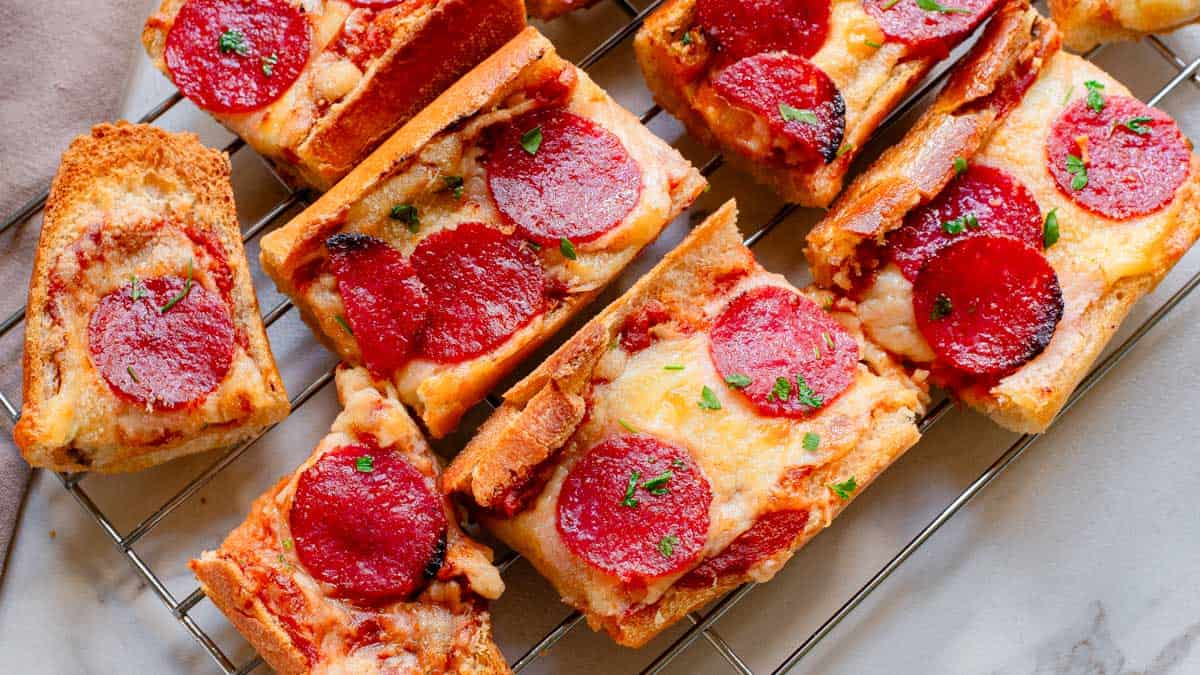 Pepperoni pizza bread on a cooling rack garnished with chopped parsley.