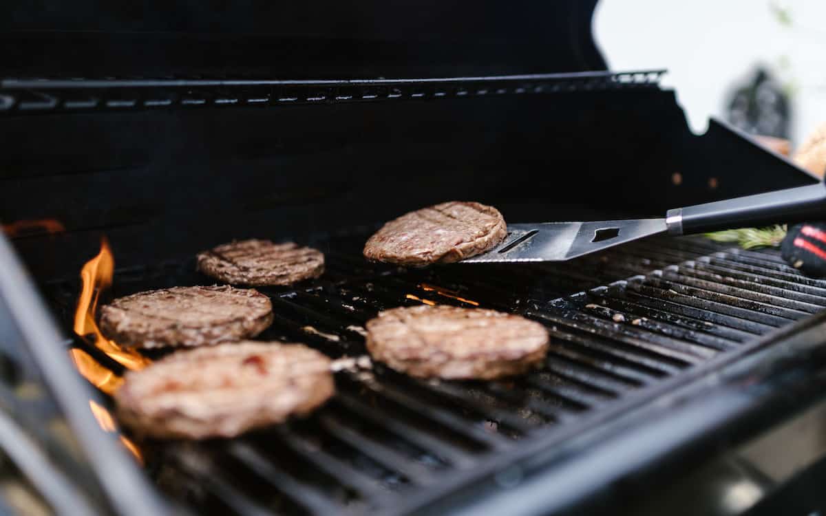 Burgers being cooked on a grill.