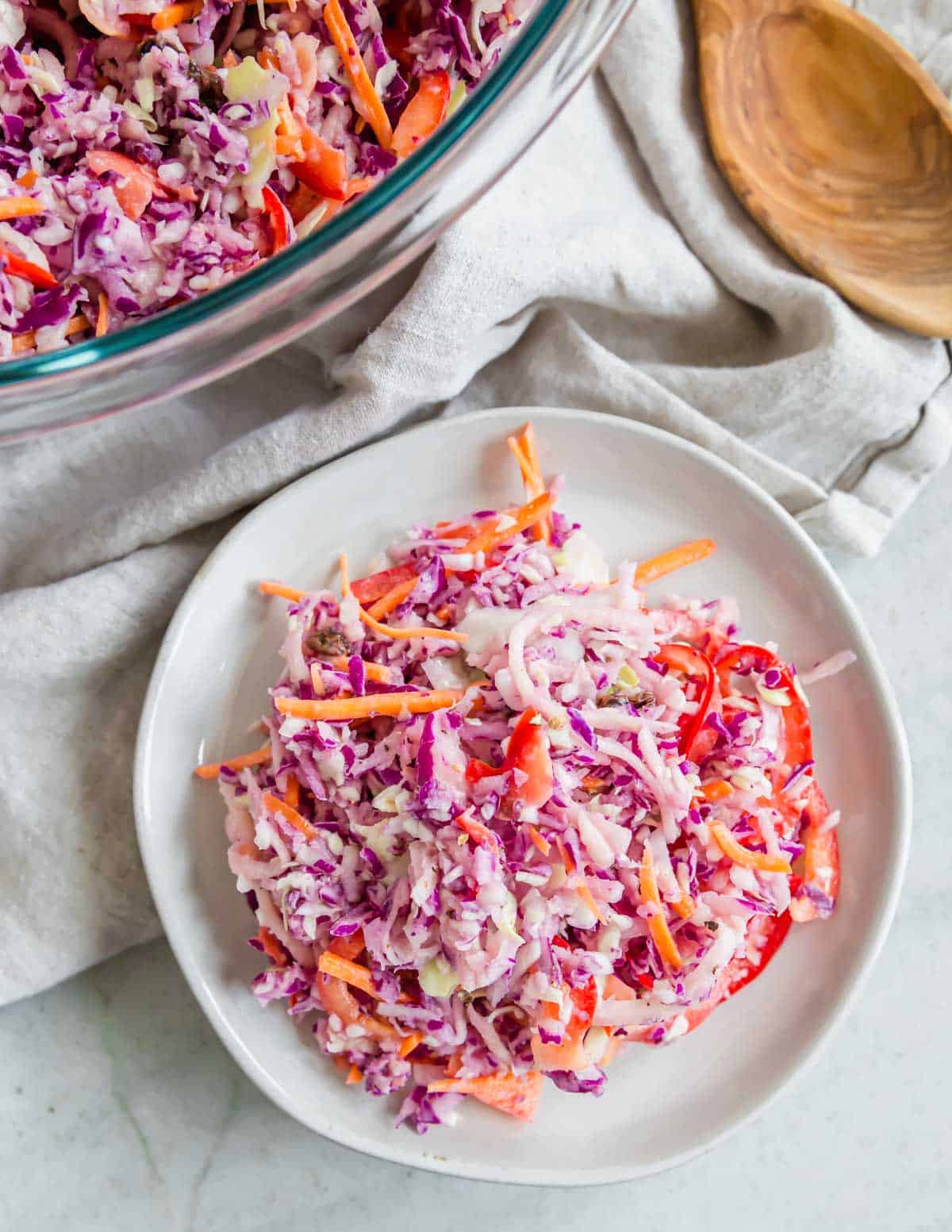 Overhead shot of Irish coleslaw recipe on a plate with bowl and serving spoon in the background.