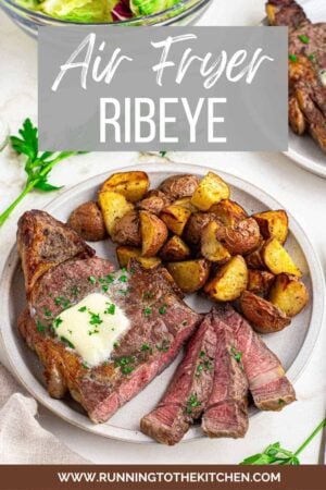 Air fryer ribeye steak on a plate cut into slices with potatoes.