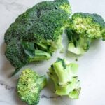 A head of broccoli with large florets broken off.