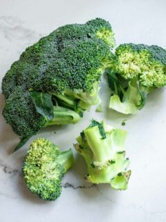 A head of broccoli with large florets broken off.