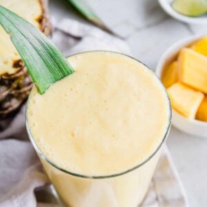 Close up of 3 ingredient mango pineapple smoothie in a glass.