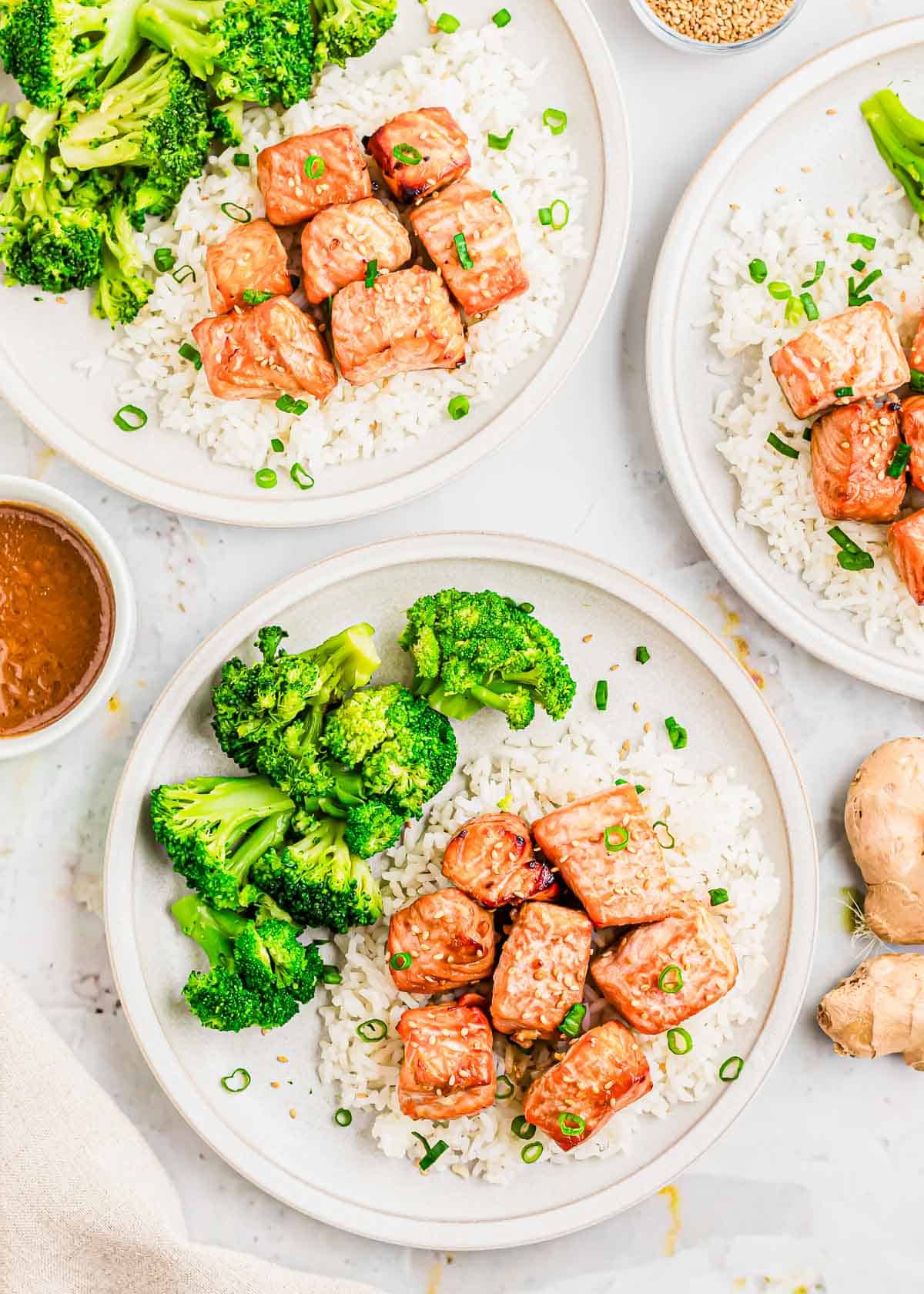 Three plates of salmon bites air fried with garlic soy sauce and ginger marinade.