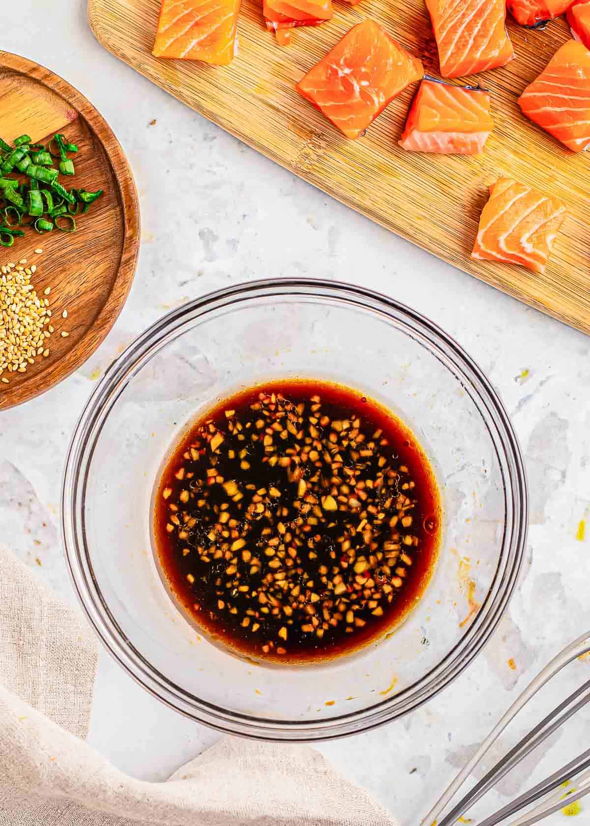 Garlic ginger soy marinade in a glass bowl for salmon bites.