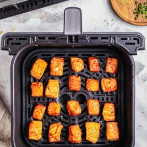 Air fried salmon bites in the air fryer basket.