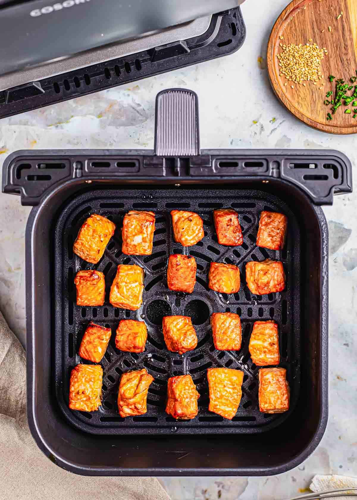 Air fried salmon bites in the air fryer basket.