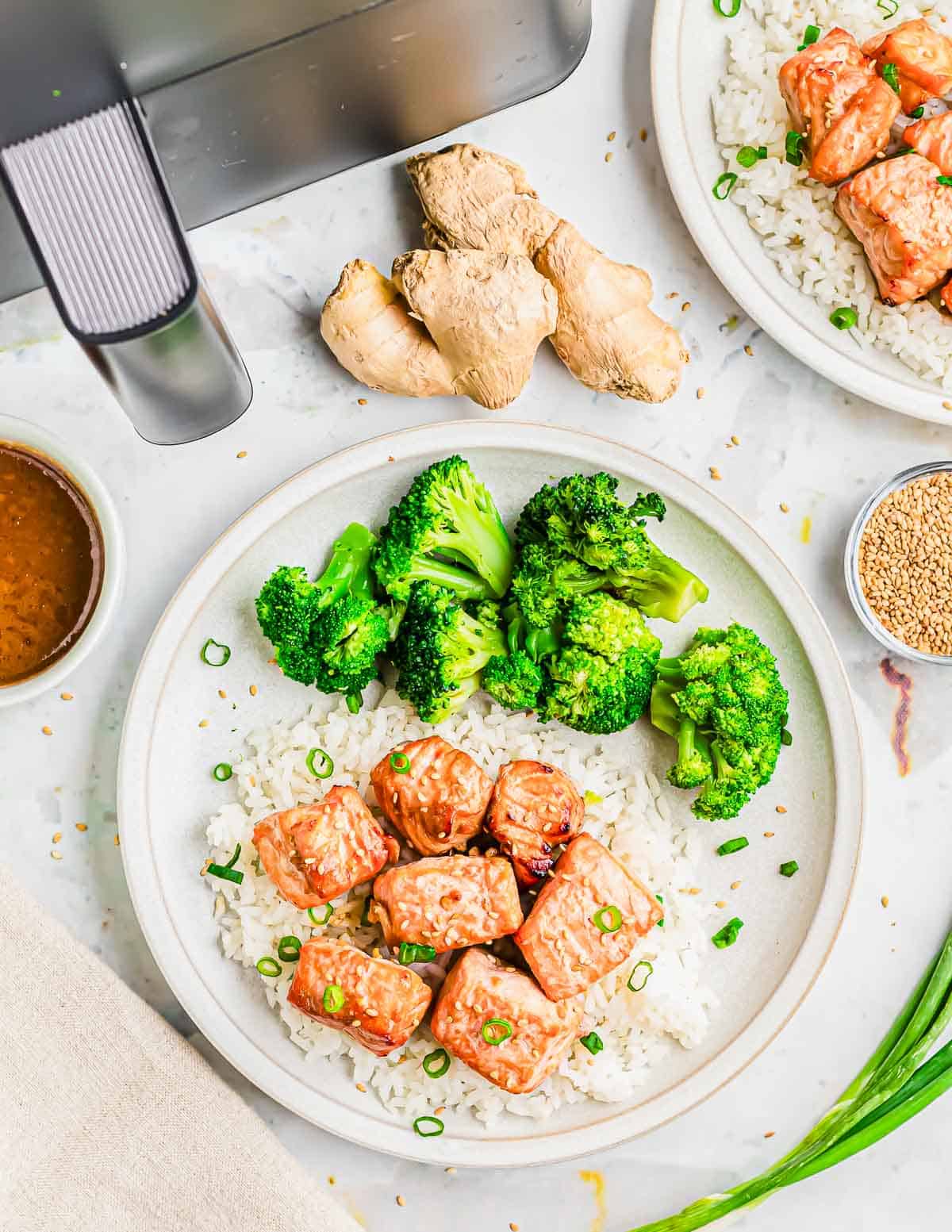 Air fryer salmon bite recipe plated with rice and broccoli.