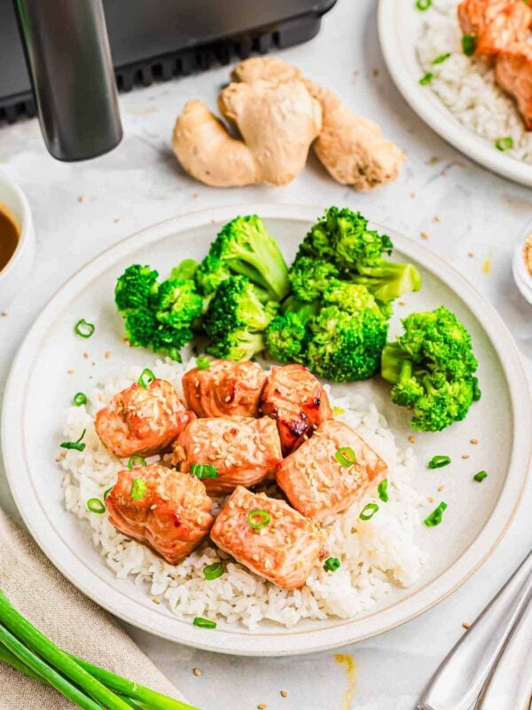 Garlic ginger soy salmon bites made in the air fryer served with white rice, broccoli and scallion garnish.