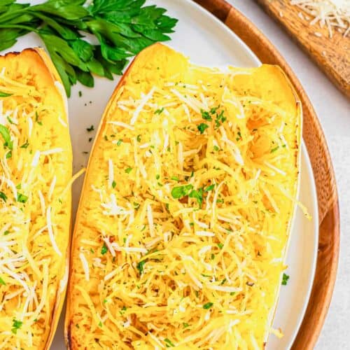 Air fryer spaghetti squash recipe with parmesan cheese on a white plate with parsley.