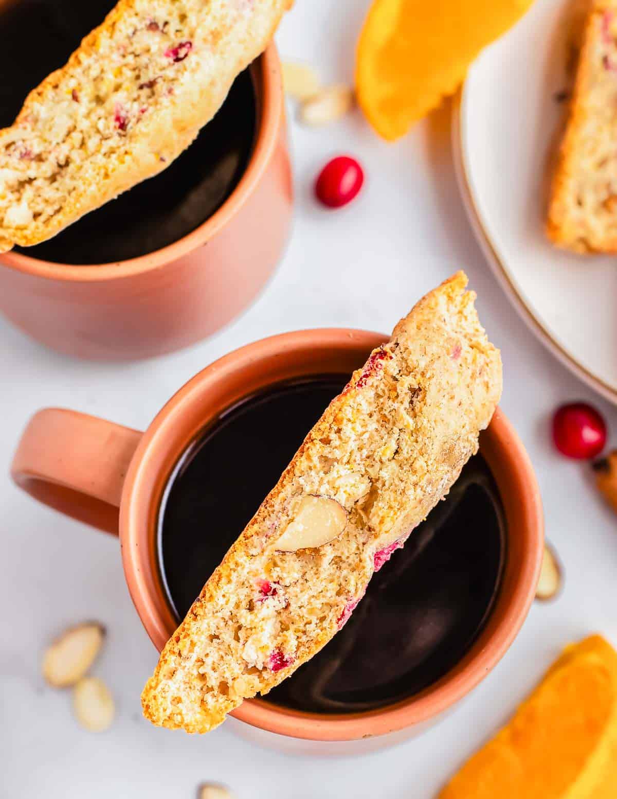 Biscotti laying on top of a mug of coffee.