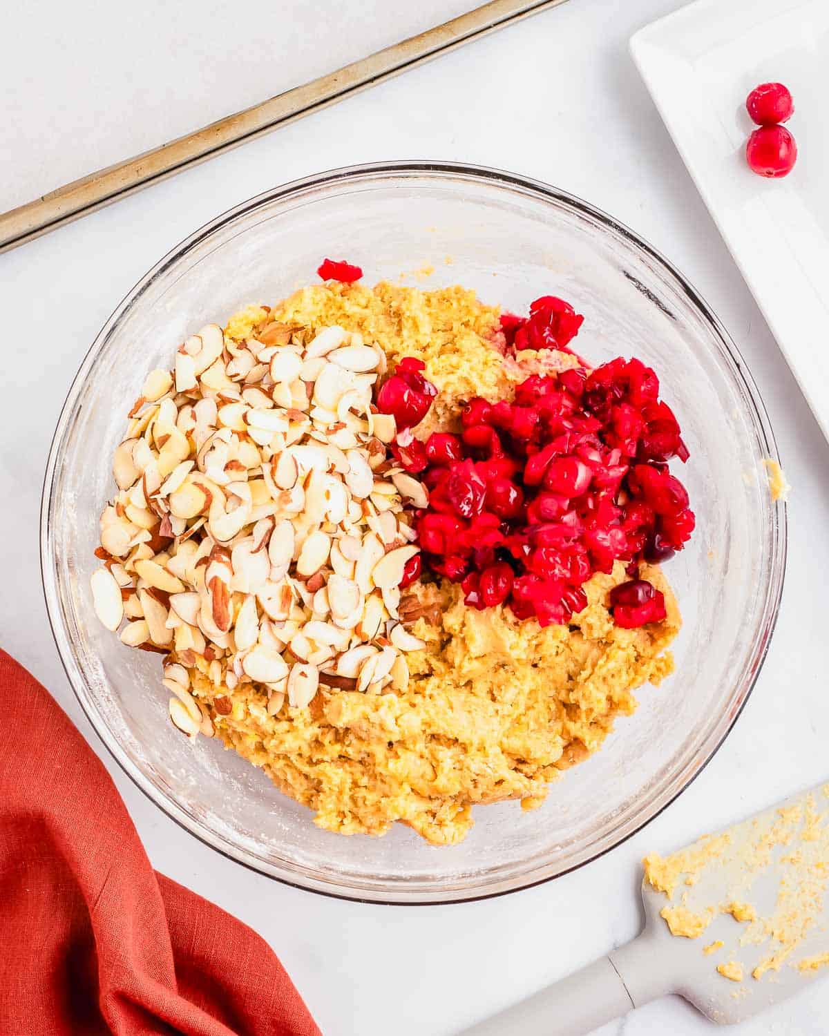 Biscotti dough with almonds, cranberries and orange in a glass bowl.