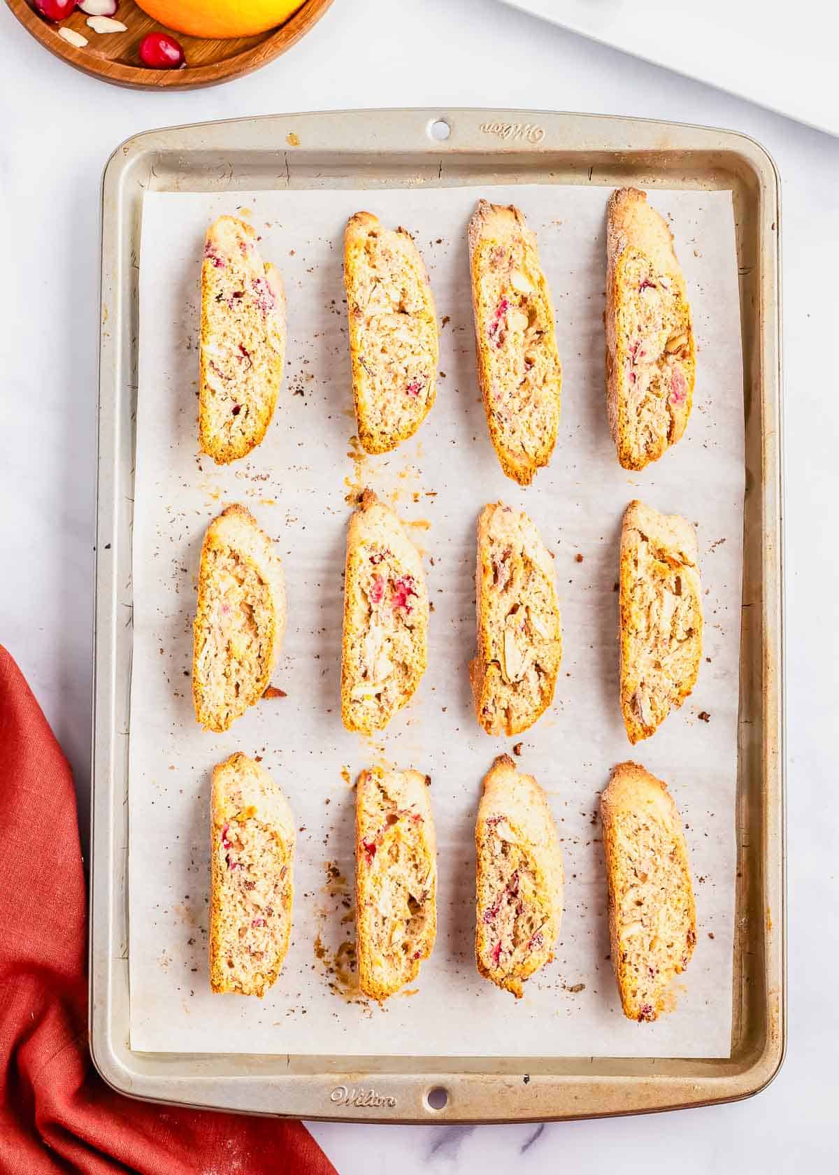 Cranberry orange biscotti cookies on a baking sheet after baking.
