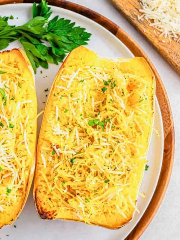 Air fryer spaghetti squash recipe with parmesan cheese on a white plate with parsley.