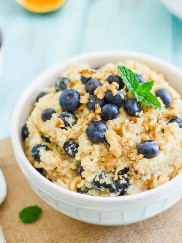 Breakfast grain bowl recipe with chopped walnuts and blueberries in a white bowl.