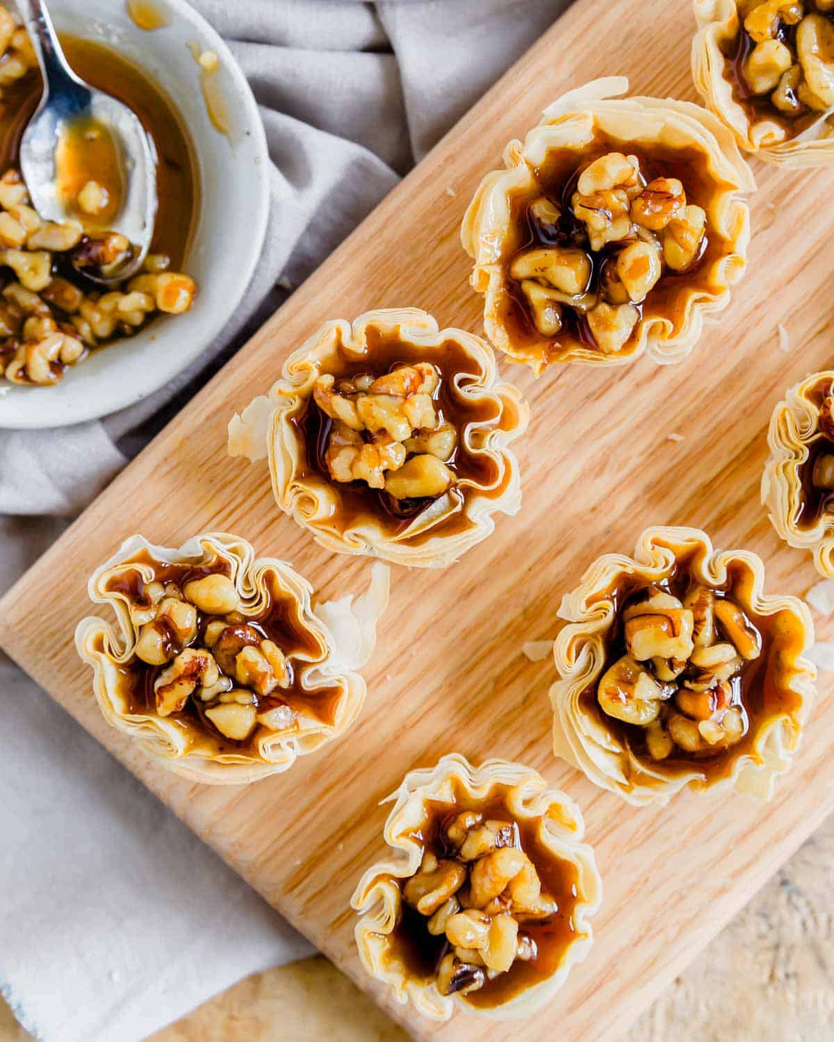 Overhead shot of mini pumpkin pie bites topped with maple walnuts.