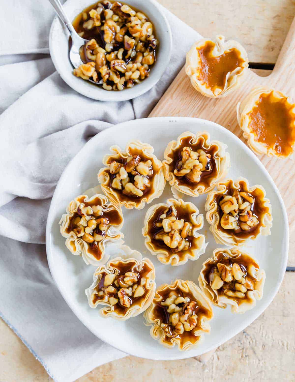 Mini phyllo dough pumpkin pie bites recipe on a white plate.