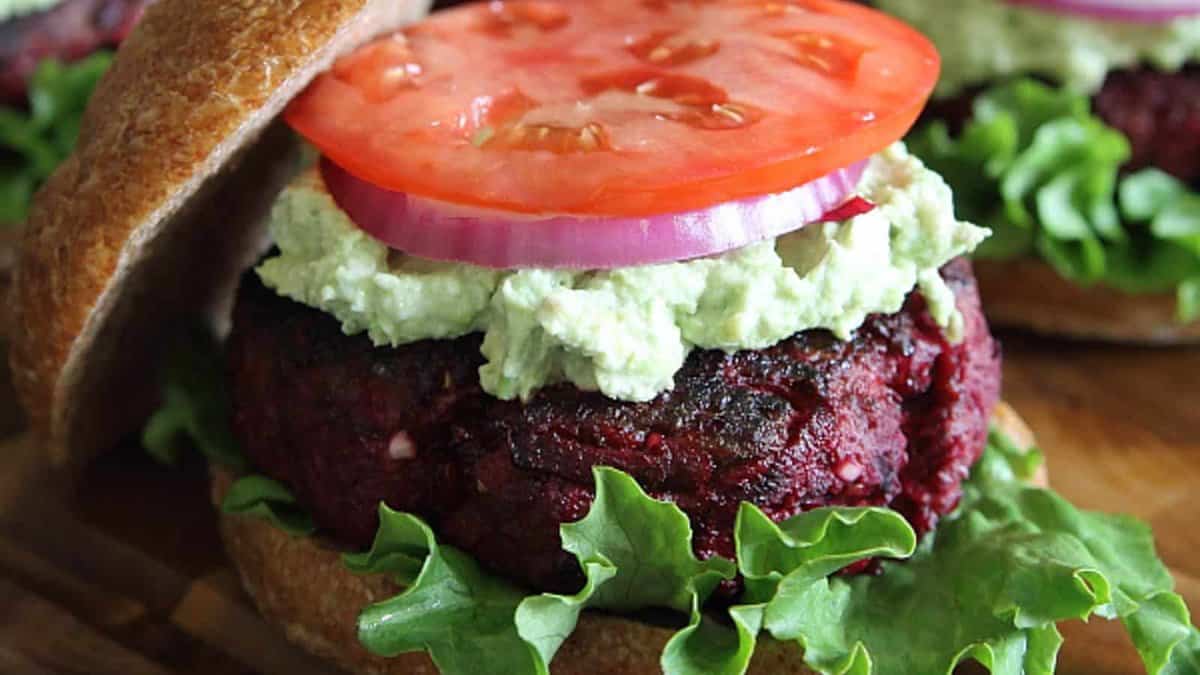 BBQ beef beet burger topped with avocado goat cheese, red onion, lettuce and tomato.