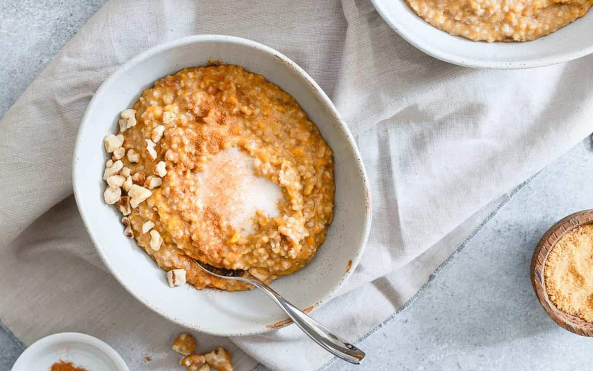 Sweet potato steel cut oats in a bowl with nuts and cream.