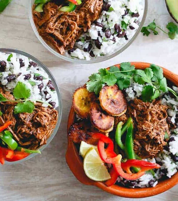 Three bowls with rice, beans and avocado.