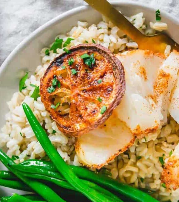 A white plate with air fryer cod and green beans on it.