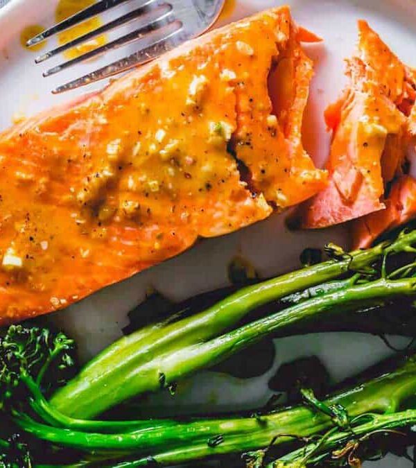 A plate with salmon and broccoli on it.