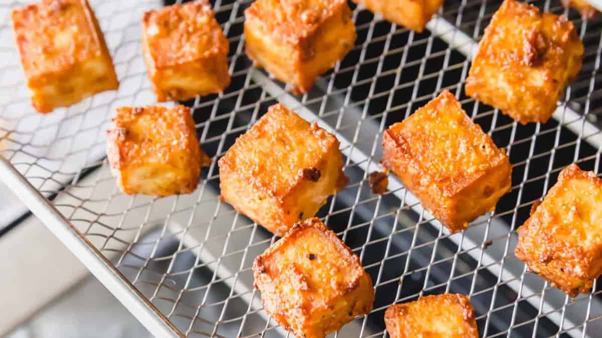 Air fried tofu cubes on a wire rack.