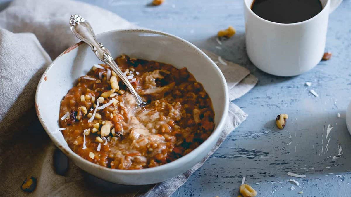 Apple butter carrot cake oatmeal in a bowl with a spoon.