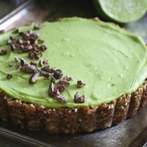 A lime tart on a plate with chocolate chips.