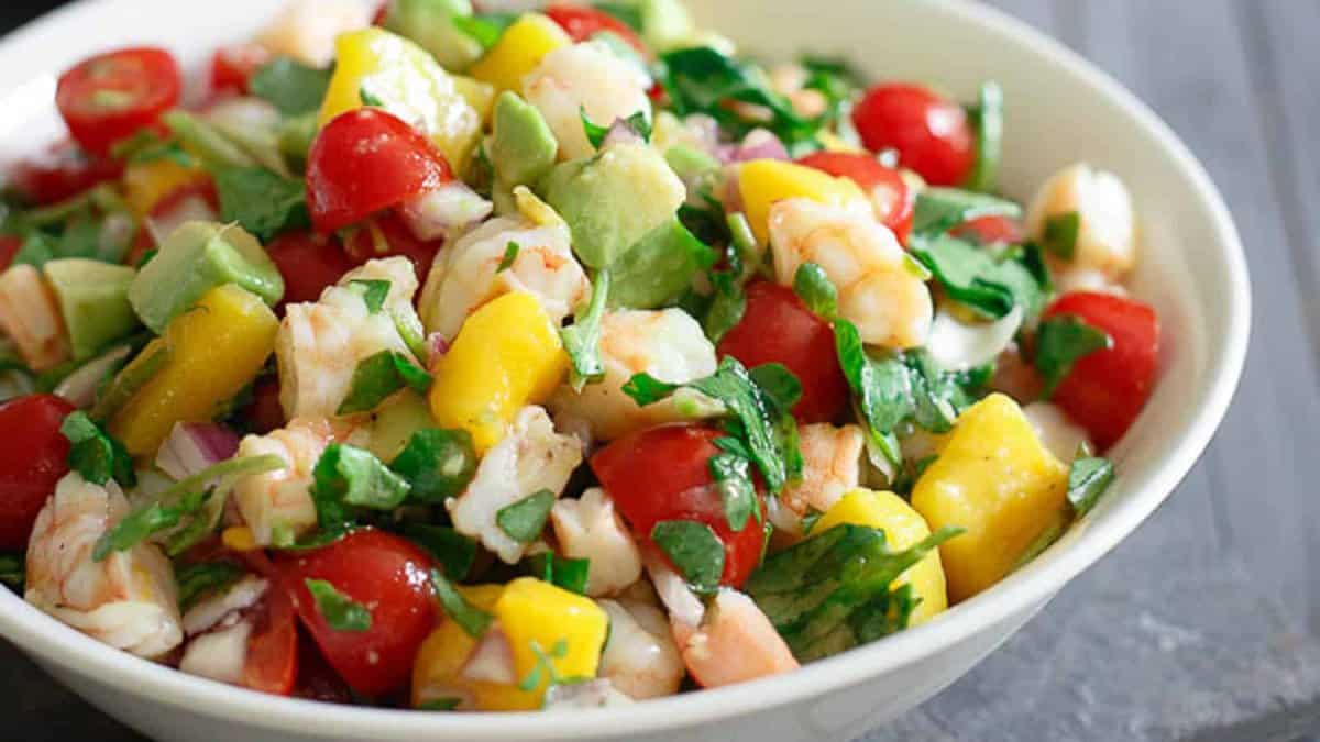 Shrimp avocado mango salad with lime dressing in a bowl.