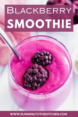 A blackberry smoothie in a glass with a straw.
