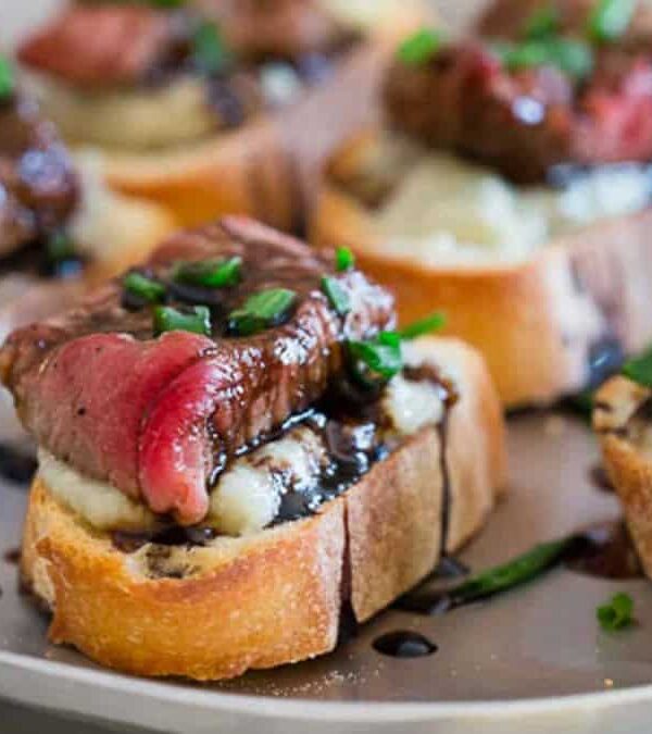 A plate of appetizers with steak and blue cheese.