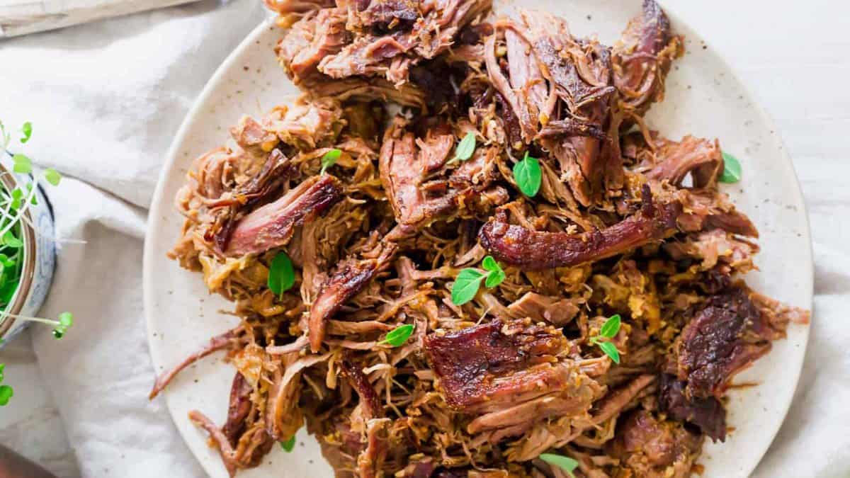 Shredded braised leg of lamb on a plate.