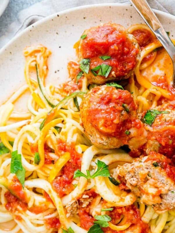 Cheddar cheese stuffed turkey meatballs on a plate with zoodles.