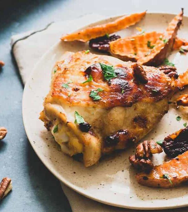 Chicken and sweet potatoes with pecans on a plate.