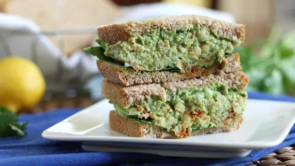Chickpea pesto and avocado sandwiches on a plate.