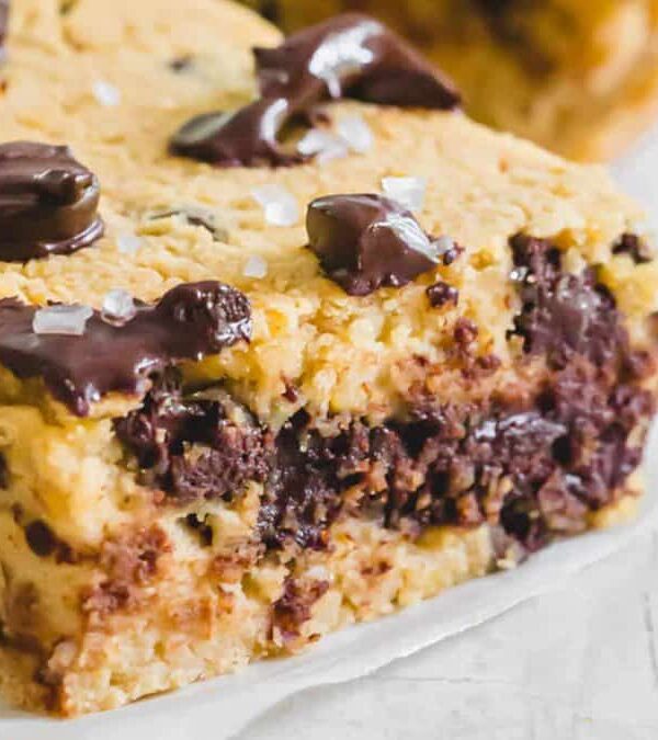 A piece of chocolate chip cookie bar on a piece of paper.