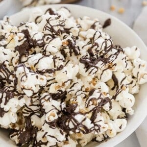 Chocolate covered popcorn in a white bowl.