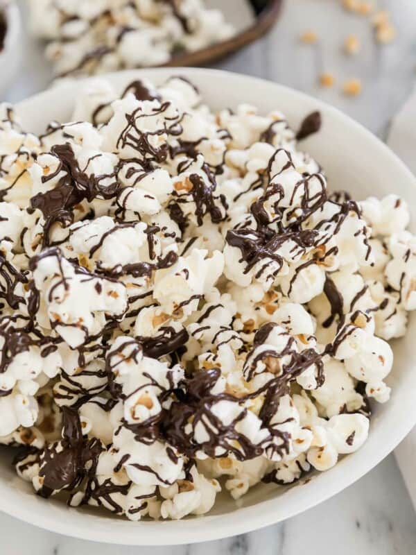 Chocolate covered popcorn in a white bowl.